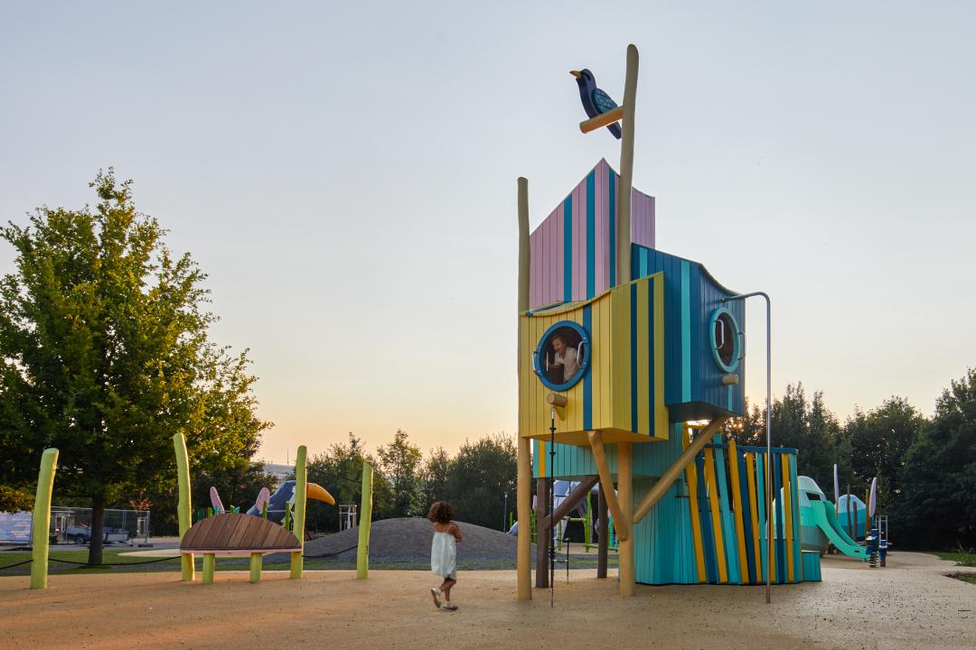 Kids playing in giant wooden birdhouses at Bird Haven Playground