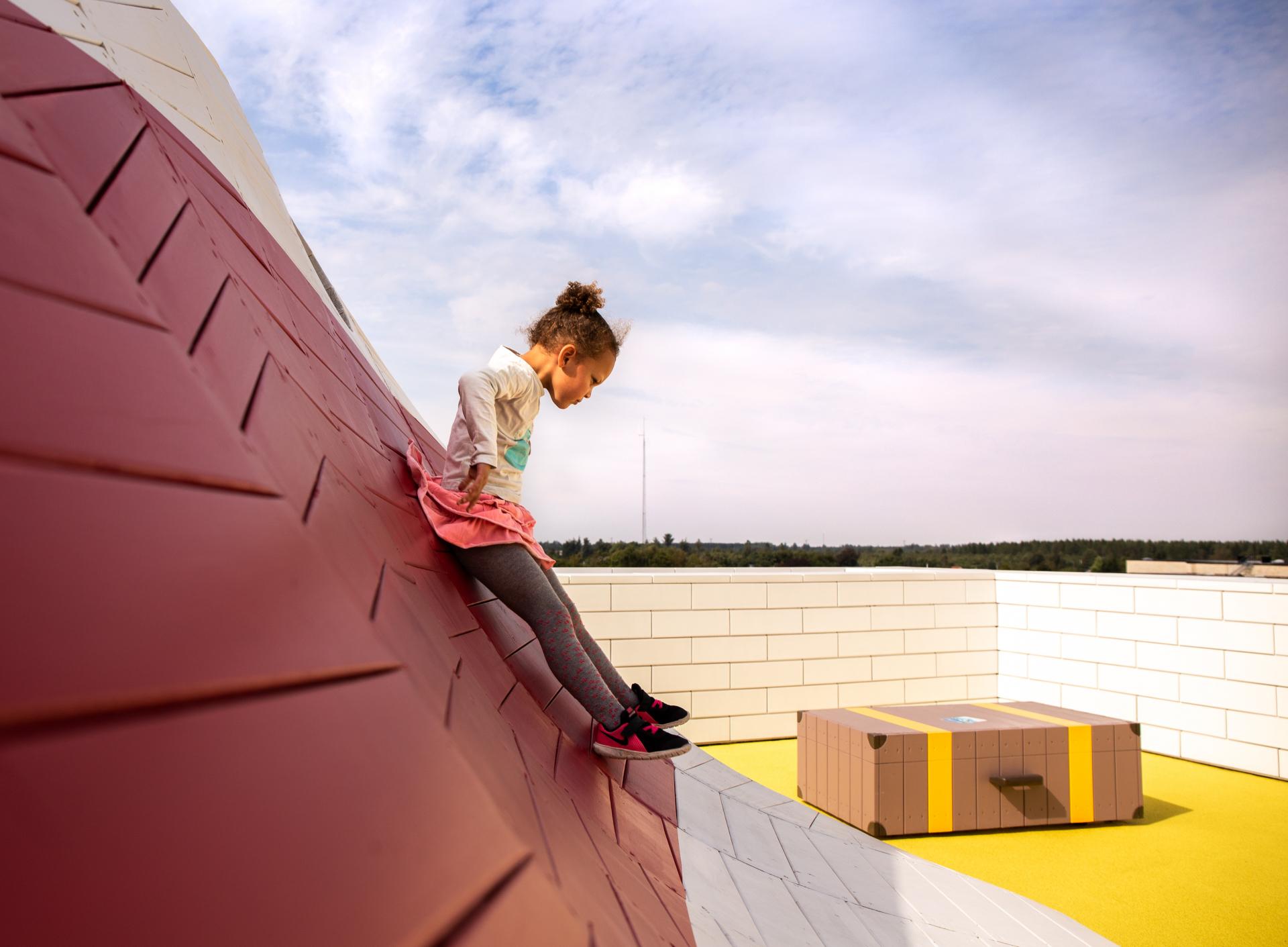 Girl sliding down playground structure