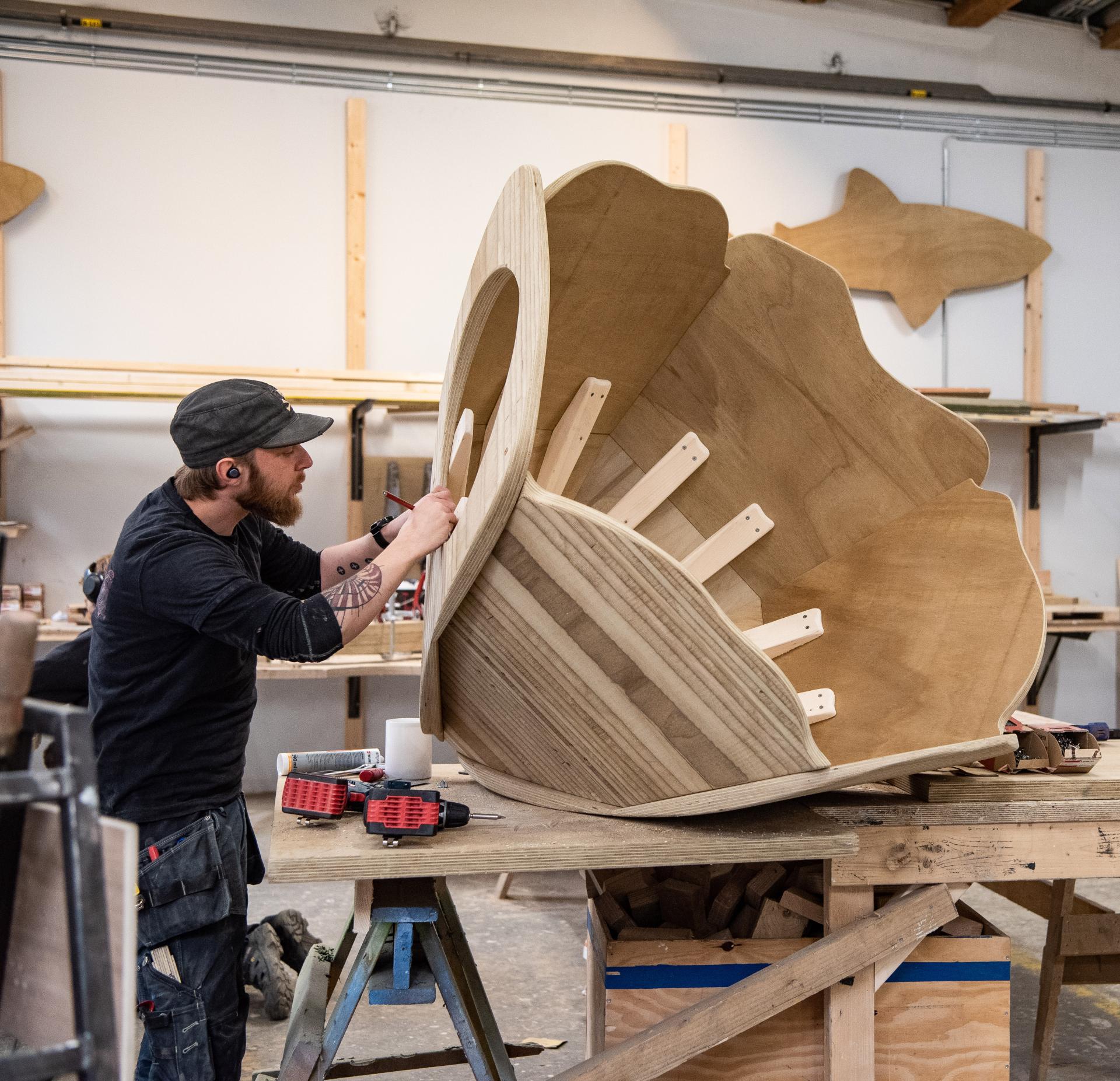 Carpenter working on wooden flower sculpture for playground