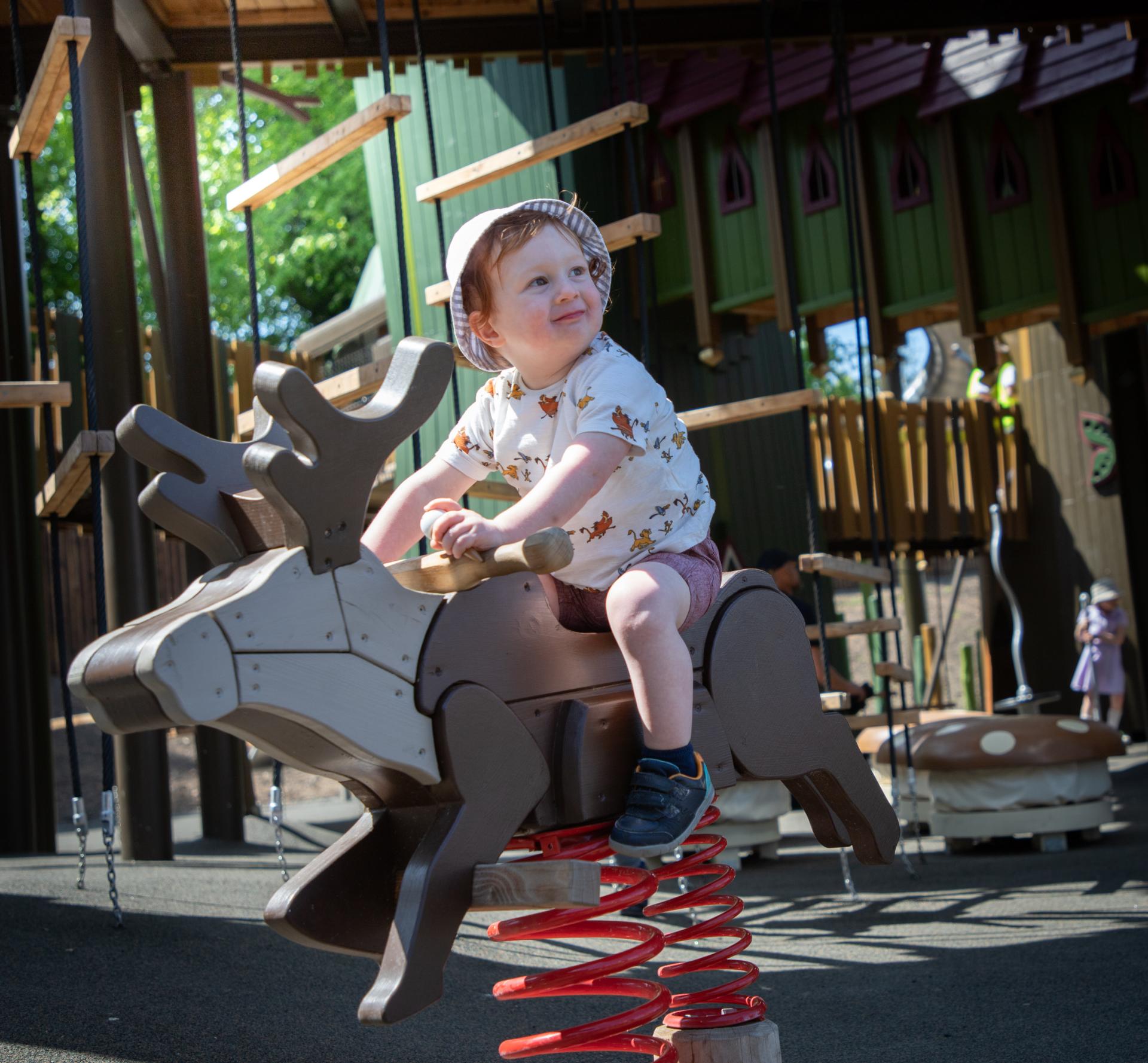 Young boy playing on rocking reindeer at Lilidorei playground