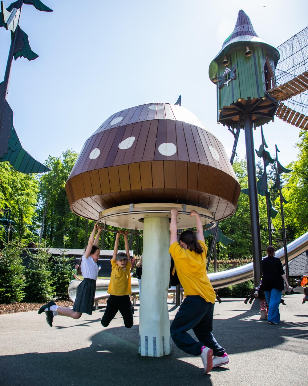 Kids spinning round on mushroom carrousel at Lilidorei playground